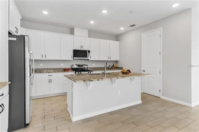 a white kitchen with cabinets and a refrigerator