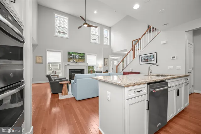 a kitchen with stainless steel appliances granite countertop a stove and a wooden floors