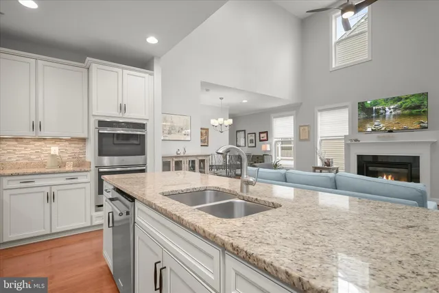 a kitchen with granite countertop a sink stainless steel appliances and cabinets