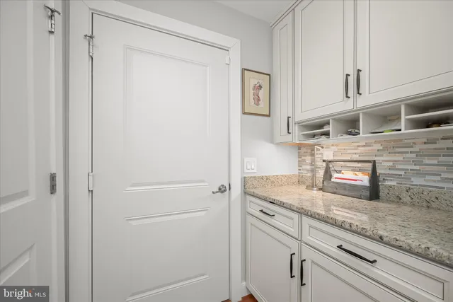 a dining room with furniture potted plants and wooden floor