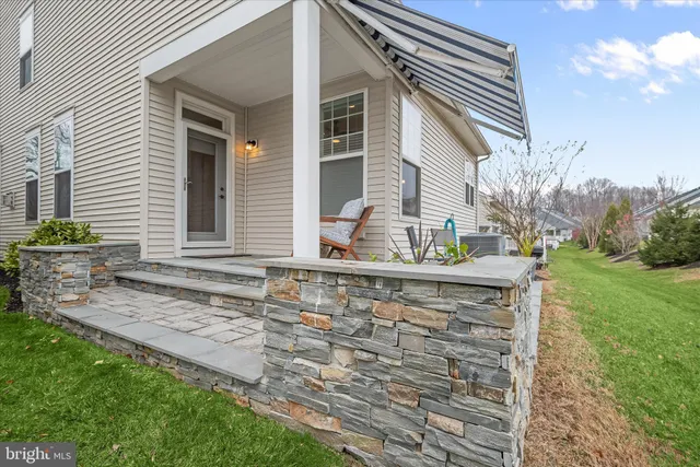 a view of a brick house with a chairs and table in a yard