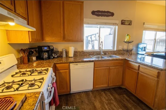 a kitchen with stainless steel appliances granite countertop a sink and wooden cabinets