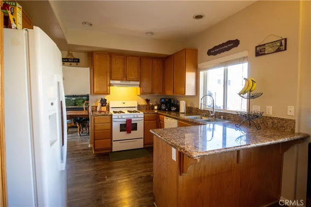a kitchen with stainless steel appliances granite countertop a sink a stove and a refrigerator