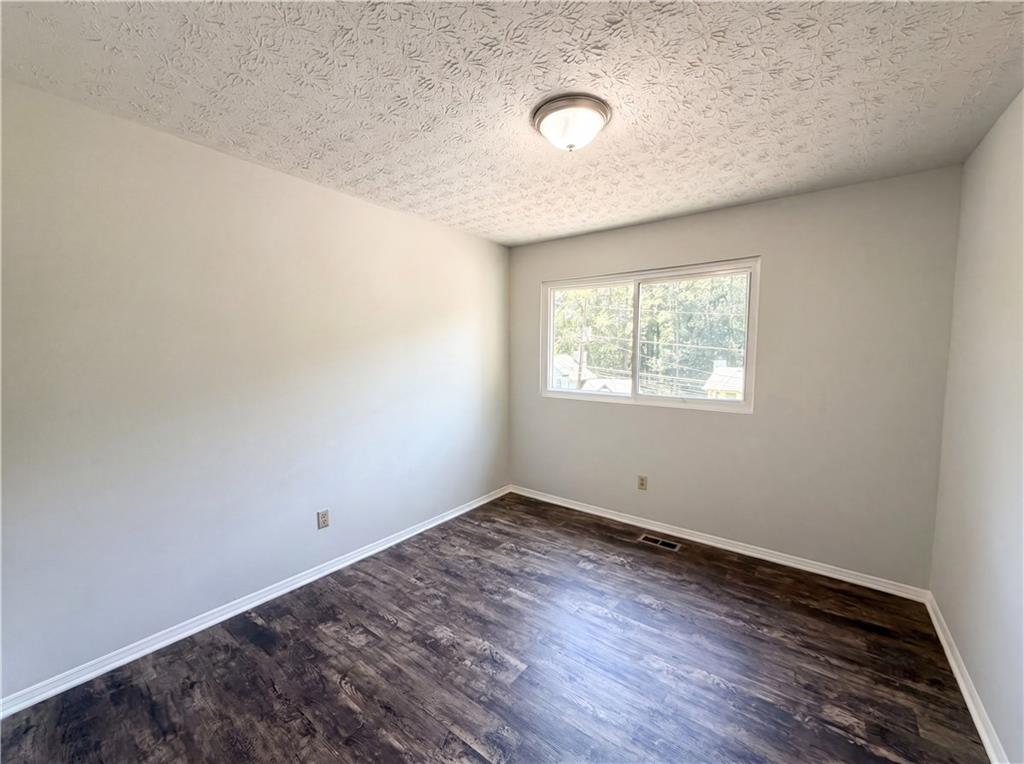 6830 Earlhurst Road Atlanta, GA 30349 - Photo 17 of 27 an empty room with wooden floor and windows