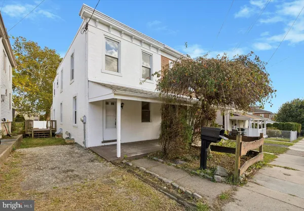 a view of a white house with a large tree and a yard