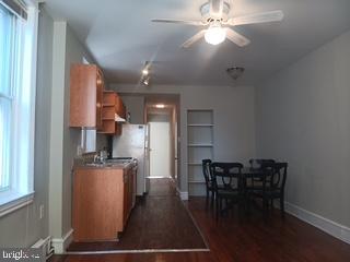 2025 South 3rd Street, Unit 2 Philadelphia, PA 19148 - Photo 6 of 8 a kitchen with kitchen island stainless steel appliances a table chairs refrigerator and cabinets