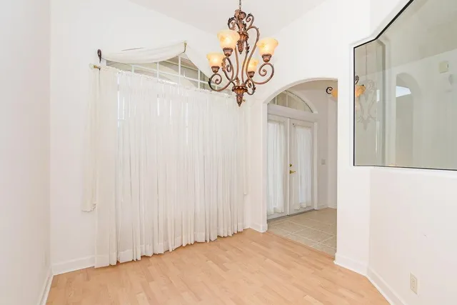 an empty room with a ceiling fan and a window