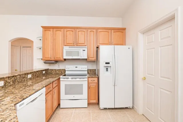 a kitchen with stainless steel appliances granite countertop a stove and a refrigerator