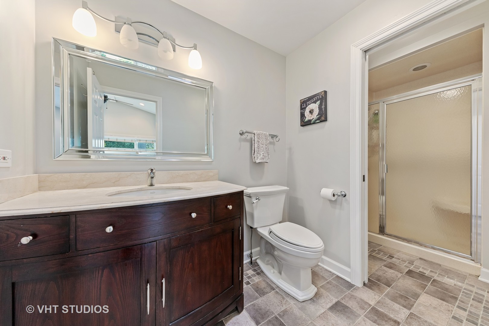 1108 Woodview Road Burr Ridge, IL 60527 - Photo 18 of 29 a bathroom with a sink a toilet a mirror and shower