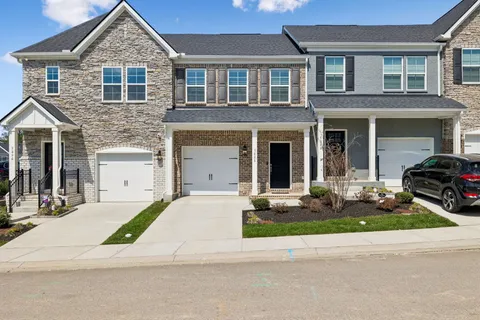 a front view of a house with garden and garage