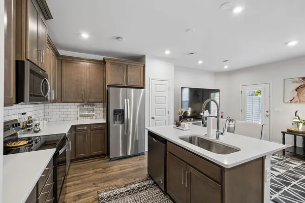a kitchen with stainless steel appliances a sink stove and refrigerator