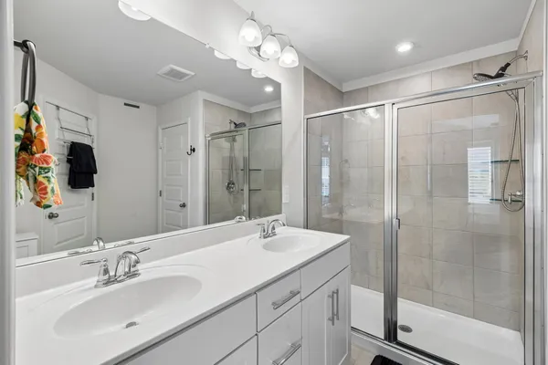 a bathroom with a shower sink vanity and mirror