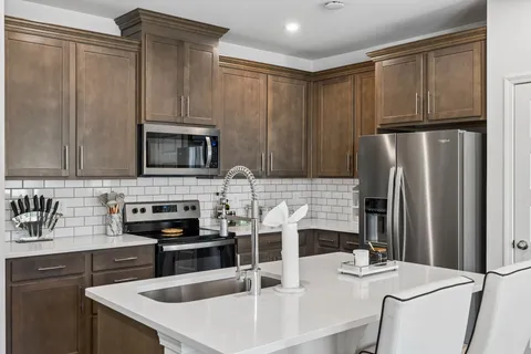 a kitchen with stainless steel appliances a refrigerator sink and stove