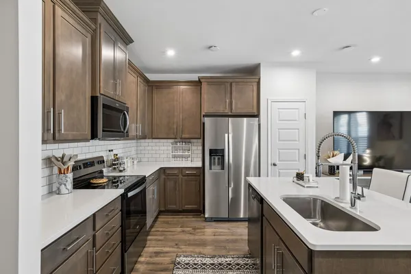 a kitchen that has a sink cabinets and stainless steel appliances