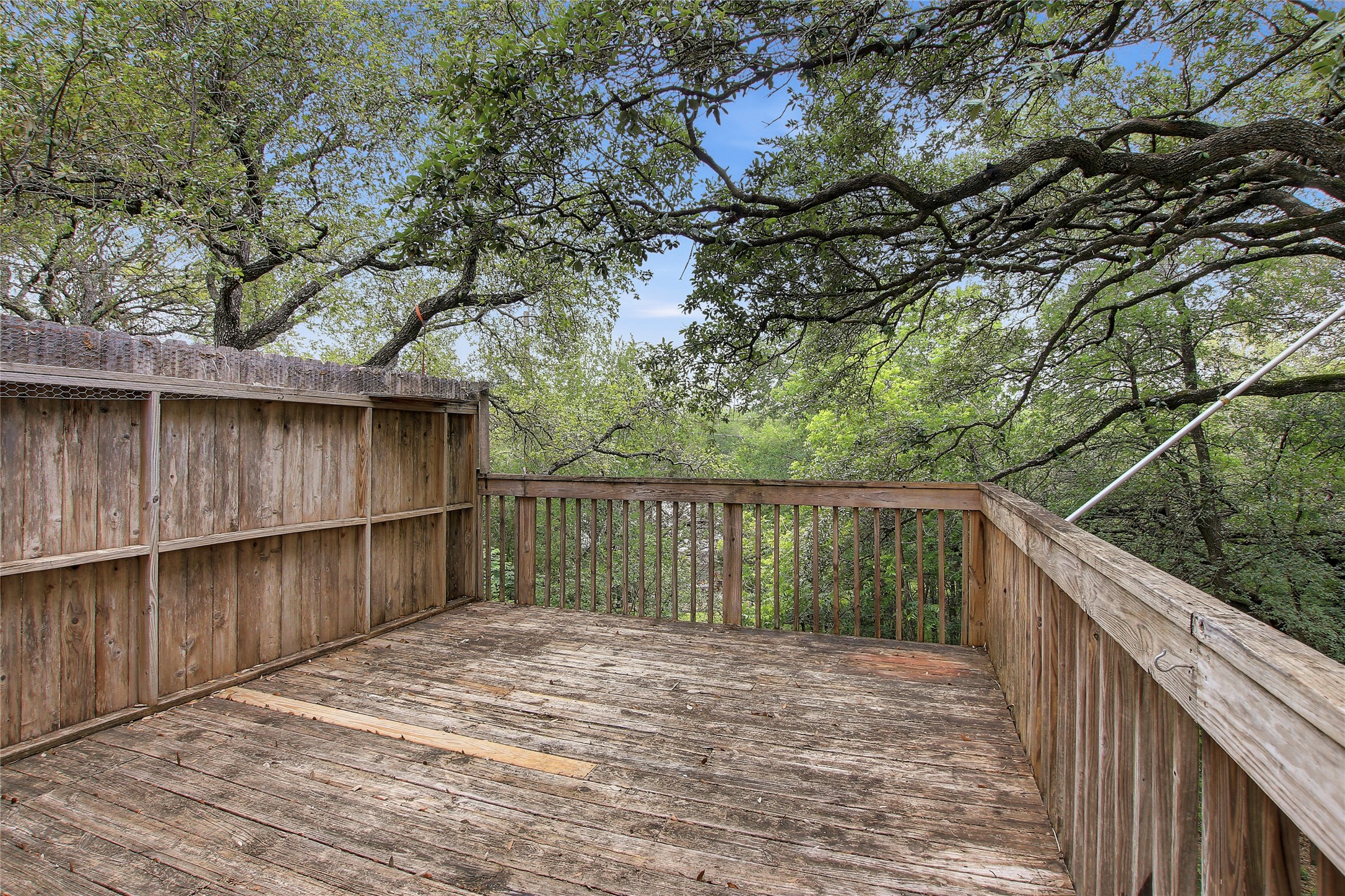 6902 Rifle Bend, Unit B Austin, TX 78736 - Photo 30 of 34 a balcony with wooden floor and fence next to a yard