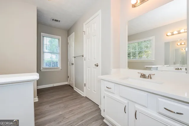 a bathroom with a sink a toilet and a window