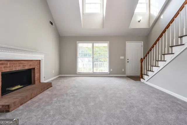 a view of empty room with fireplace and windows
