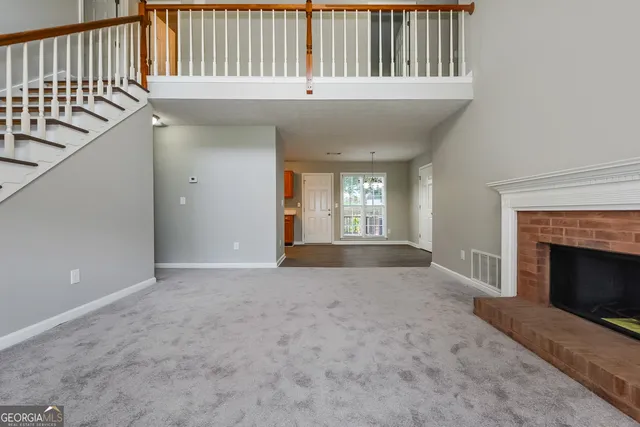 a view of an empty room with a window and fireplace