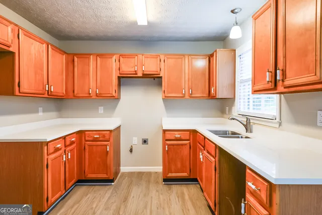 a kitchen with stainless steel appliances granite countertop a sink a stove cabinets and wooden floor