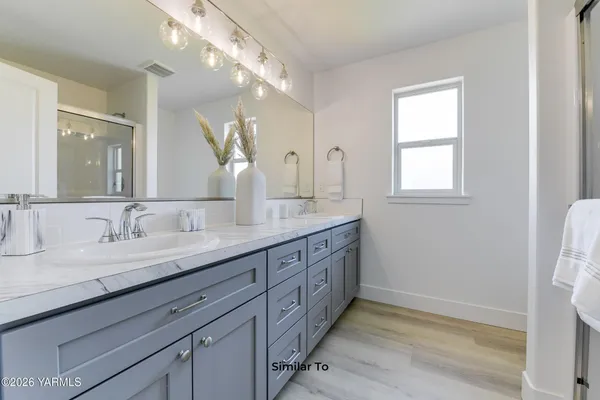 a bathroom with double sink and a mirror