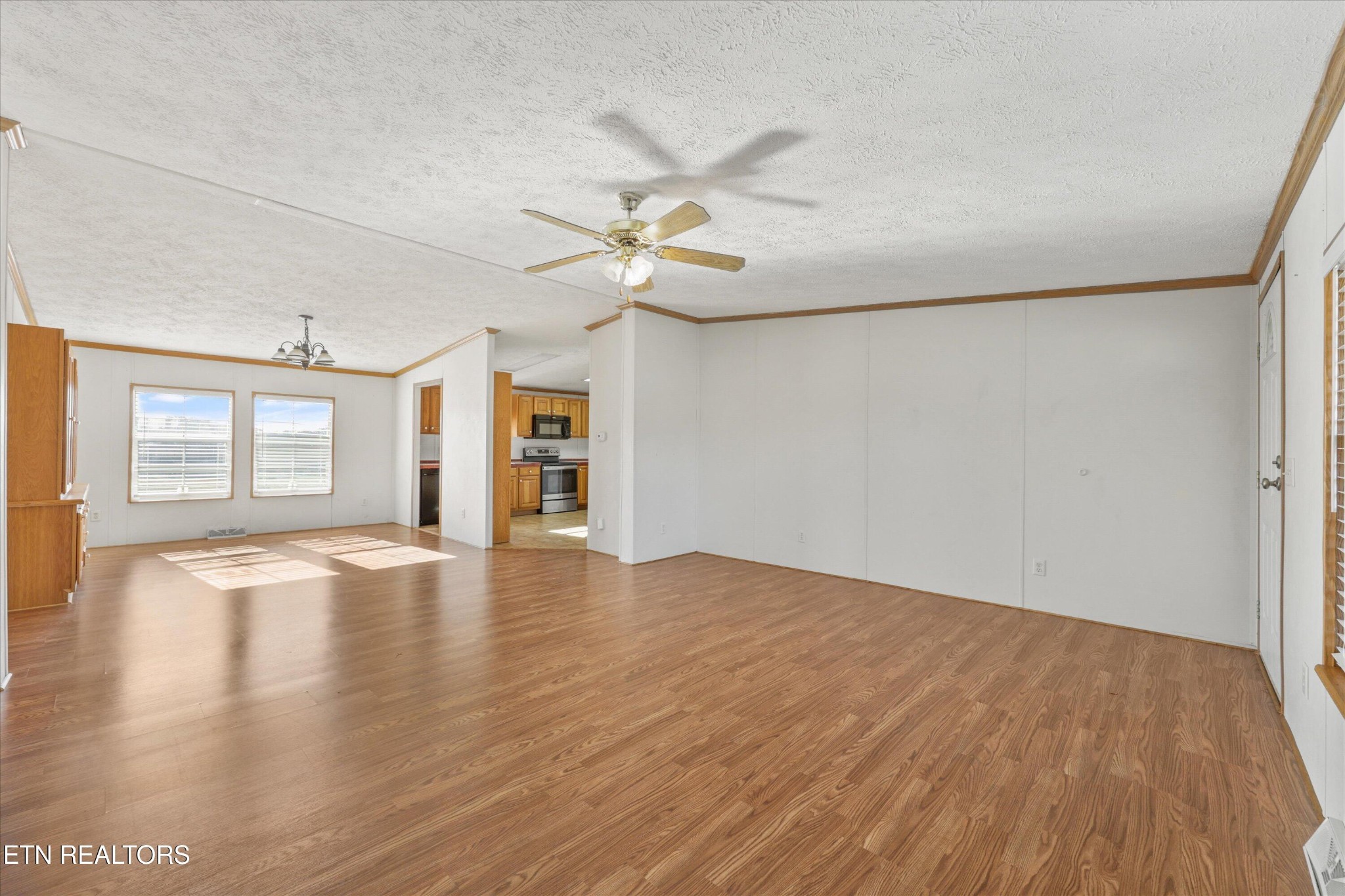 1130 Williamson Chapel Road Maryville, TN 37801 - Photo 8 of 36 an empty room with wooden floor chandelier fan and windows