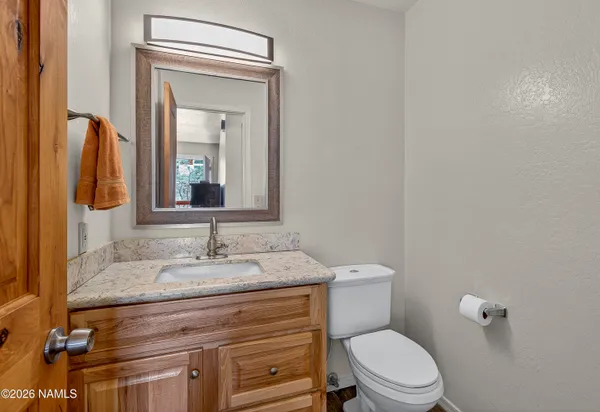 a bathroom with a granite countertop toilet sink and mirror