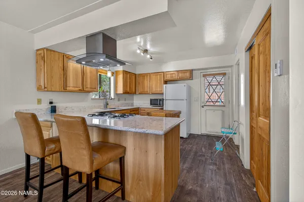 a kitchen with cabinets and wooden floor