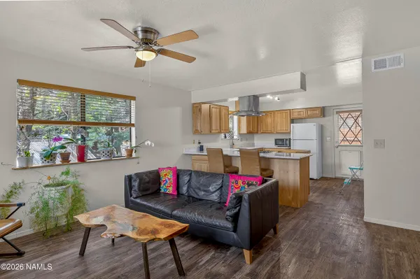 a living room with furniture kitchen view and a window