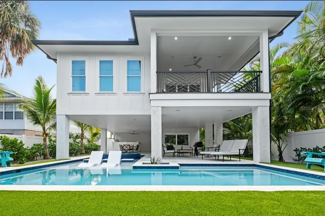 a living room with furniture kitchen view and a large window