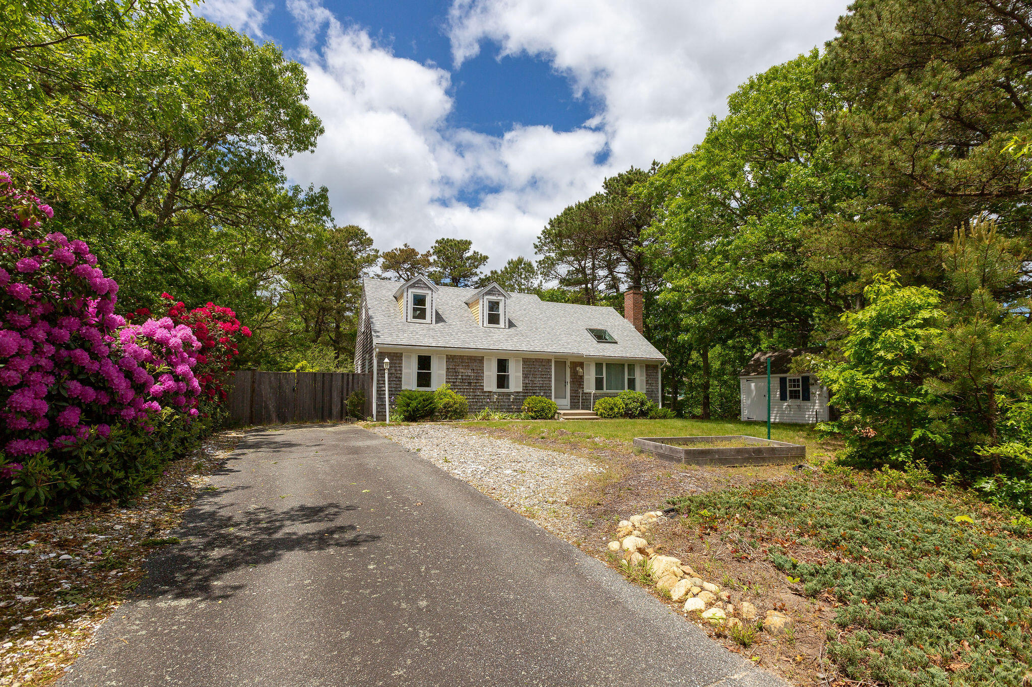 94 Pine View Drive Brewster, MA 02631 - Photo 2 of 51 a front view of a house with a yard and trees