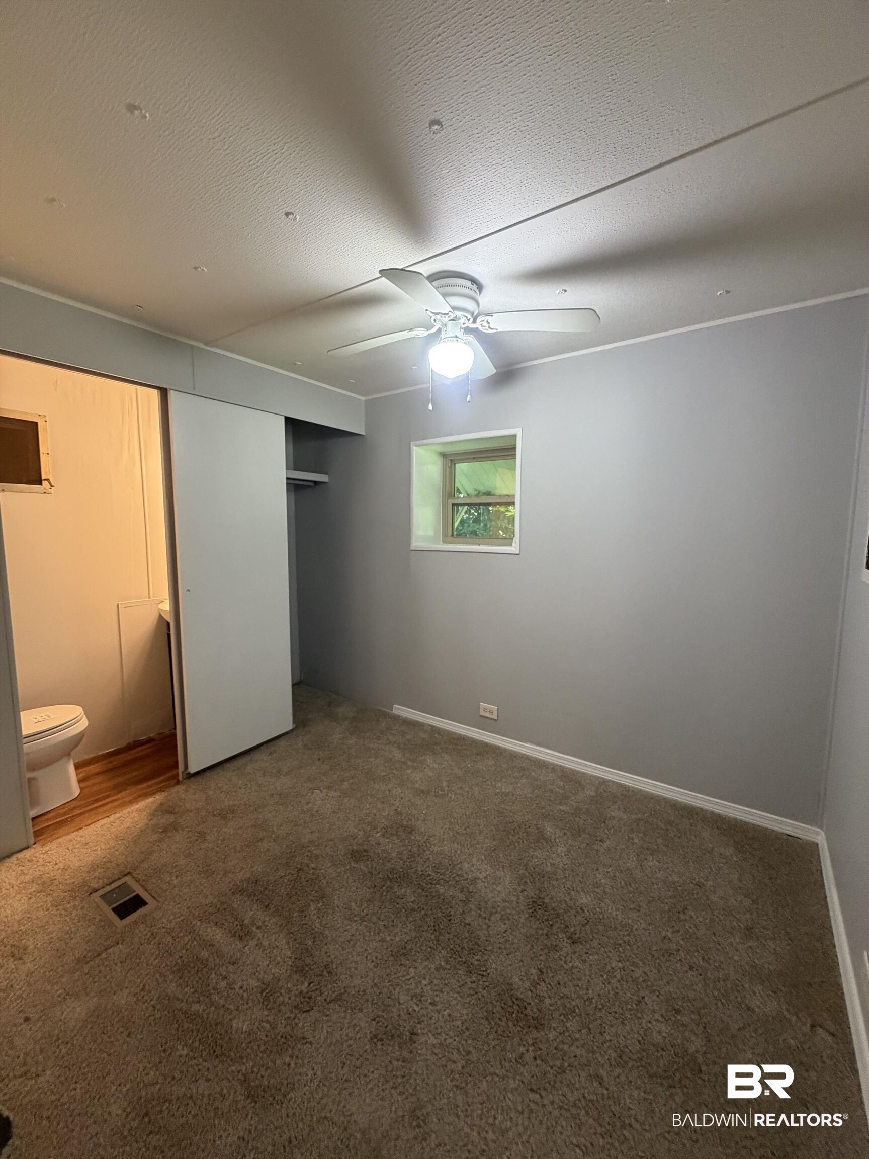 1354 Caney Loop Lillian, AL 36549 - Photo 13 of 45 Carpeted room with light gray walls, a ceiling fan with integrated lighting, and a window providing natural light