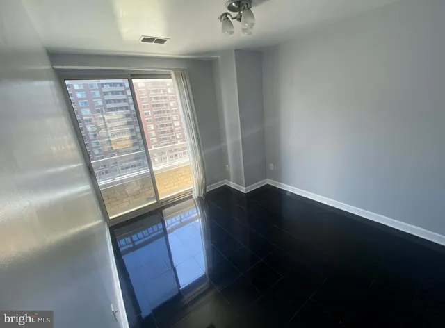 an empty room with a ceiling fan and window