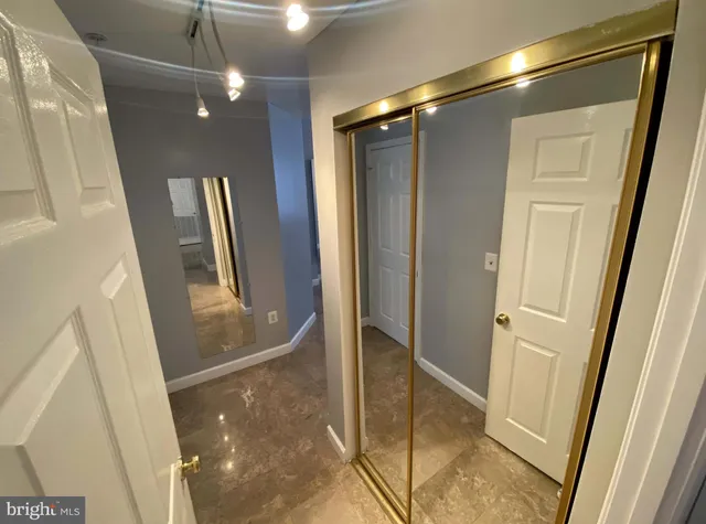 an empty room with chandelier fan and closet