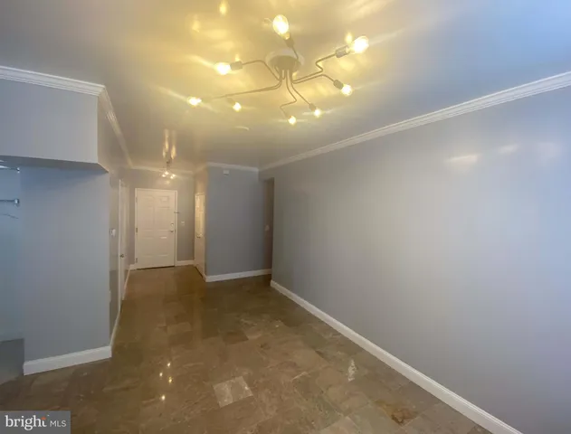 a view of an empty room with a chandelier fan