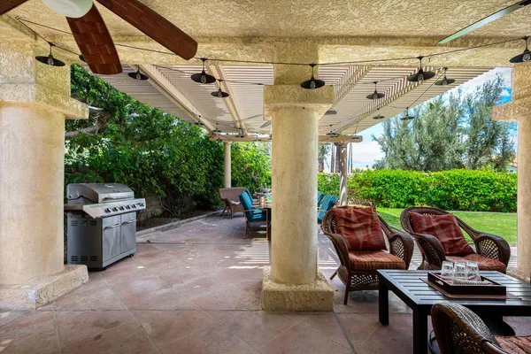 a view of a white house with a yard and potted plants