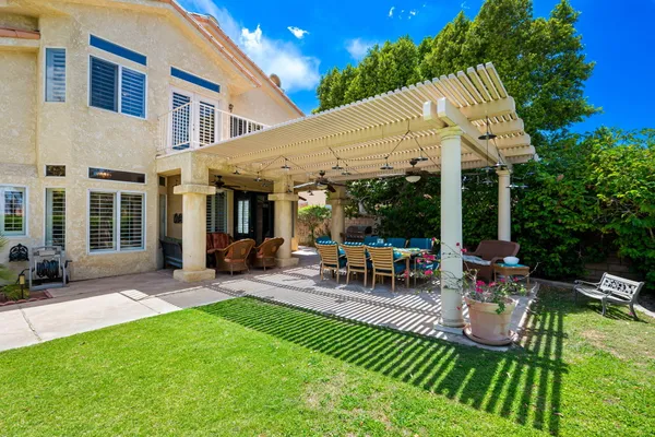 a view of a patio with a table and chairs under an umbrella