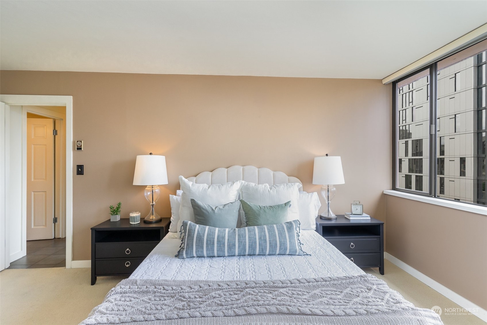 1120 8th Avenue, Unit 1601 Seattle, WA 98101 - Photo 11 of 30 a bed sitting in a bedroom and next to a lamp