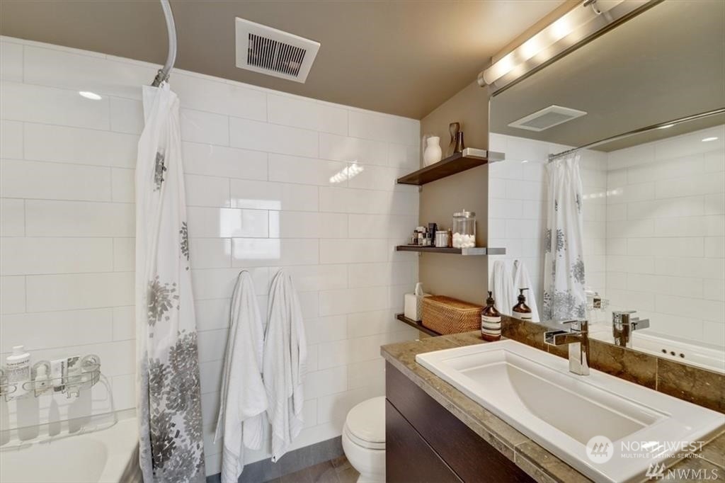 1120 8th Avenue, Unit 1601 Seattle, WA 98101 - Photo 13 of 30 a bathroom with a sink a toilet and shower