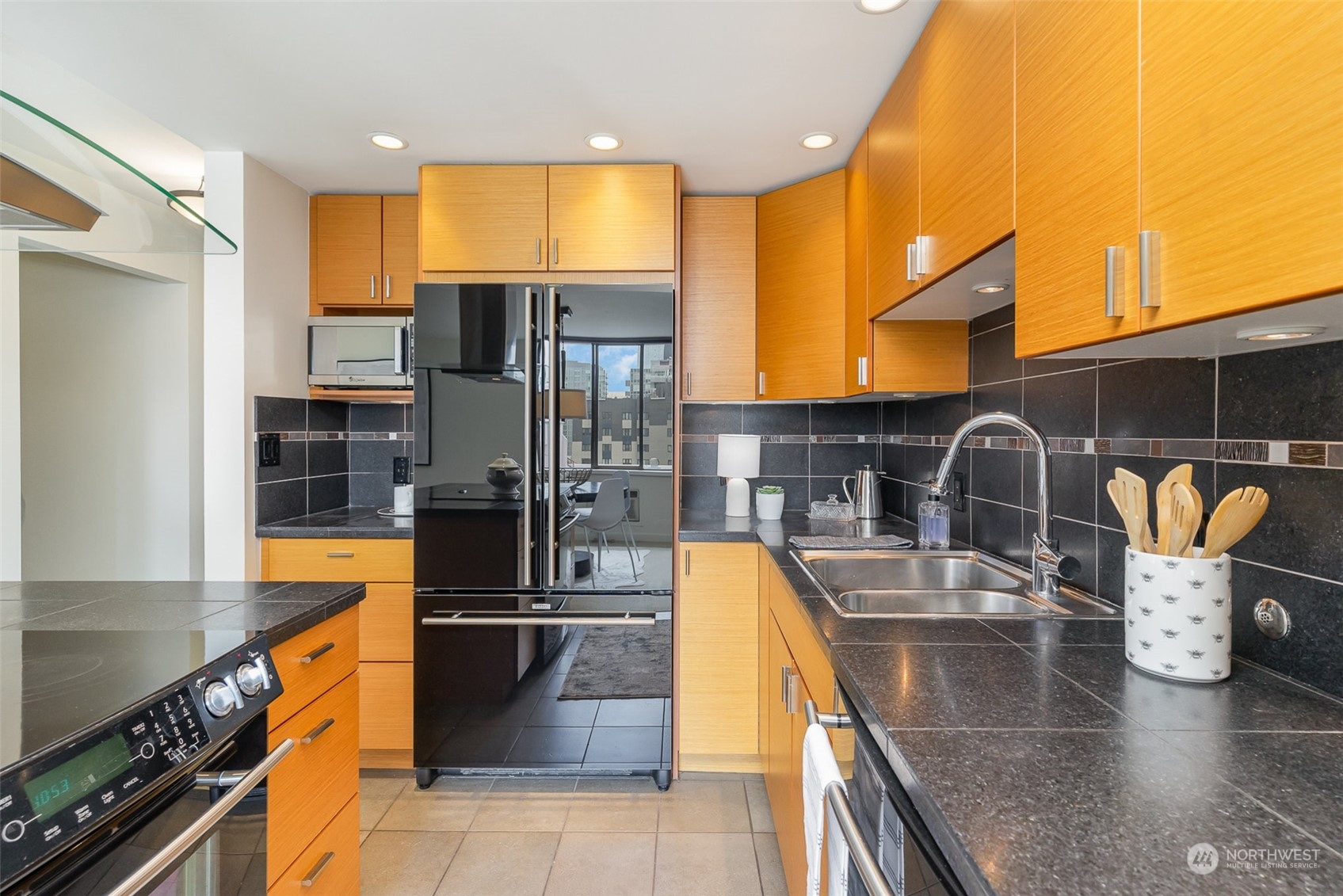 1120 8th Avenue, Unit 1601 Seattle, WA 98101 - Photo 6 of 30 a kitchen with stainless steel appliances granite countertop a sink and a refrigerator