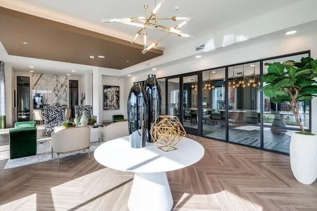 a living room with furniture a chandelier and a dining table with wooden floor