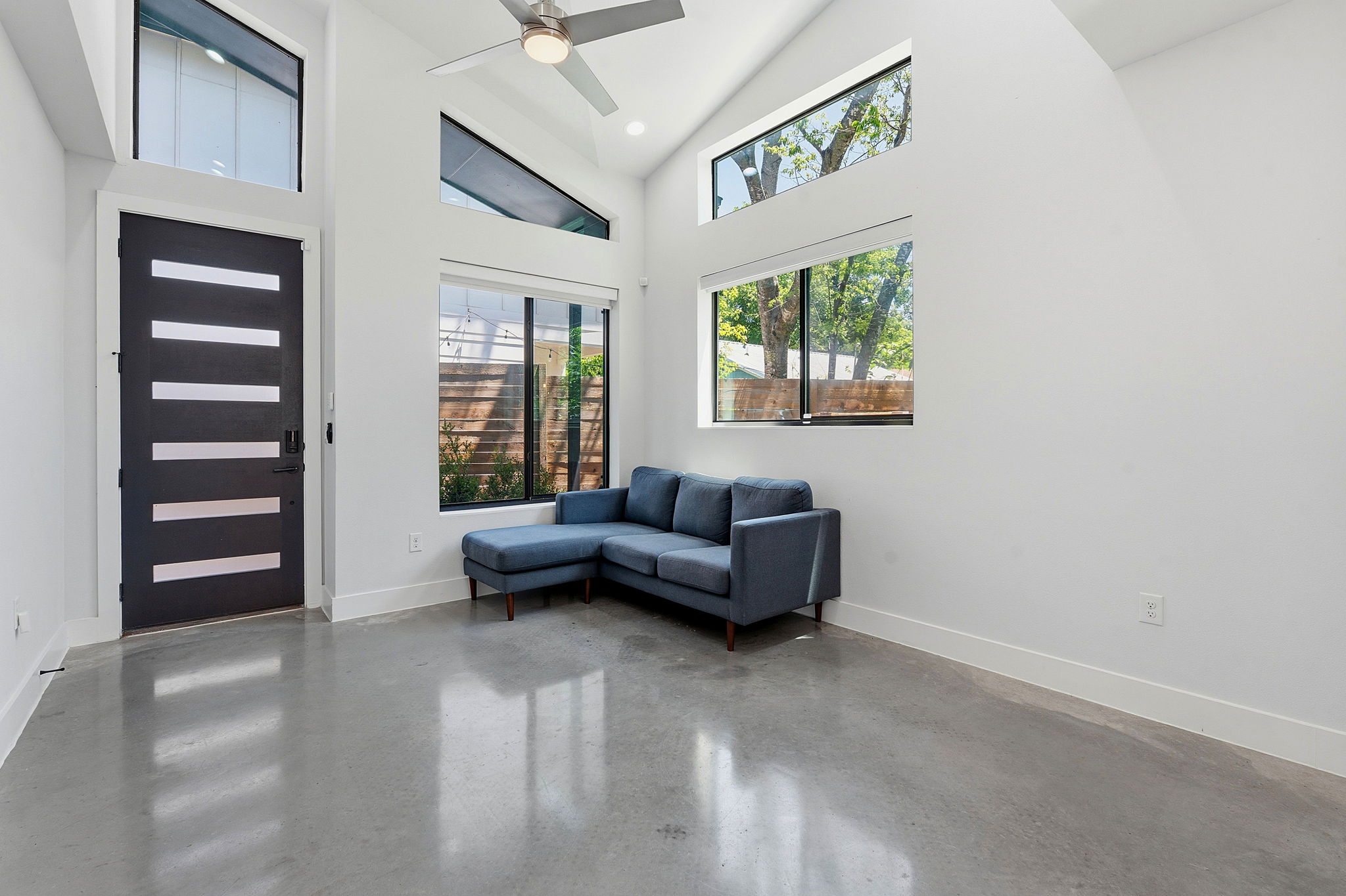 2935 Moss Street, Unit 2 Austin, TX 78722 - Photo 6 of 20 Polished concrete flooring grounds this open living space with soaring vaulted ceilings and expansive windows.