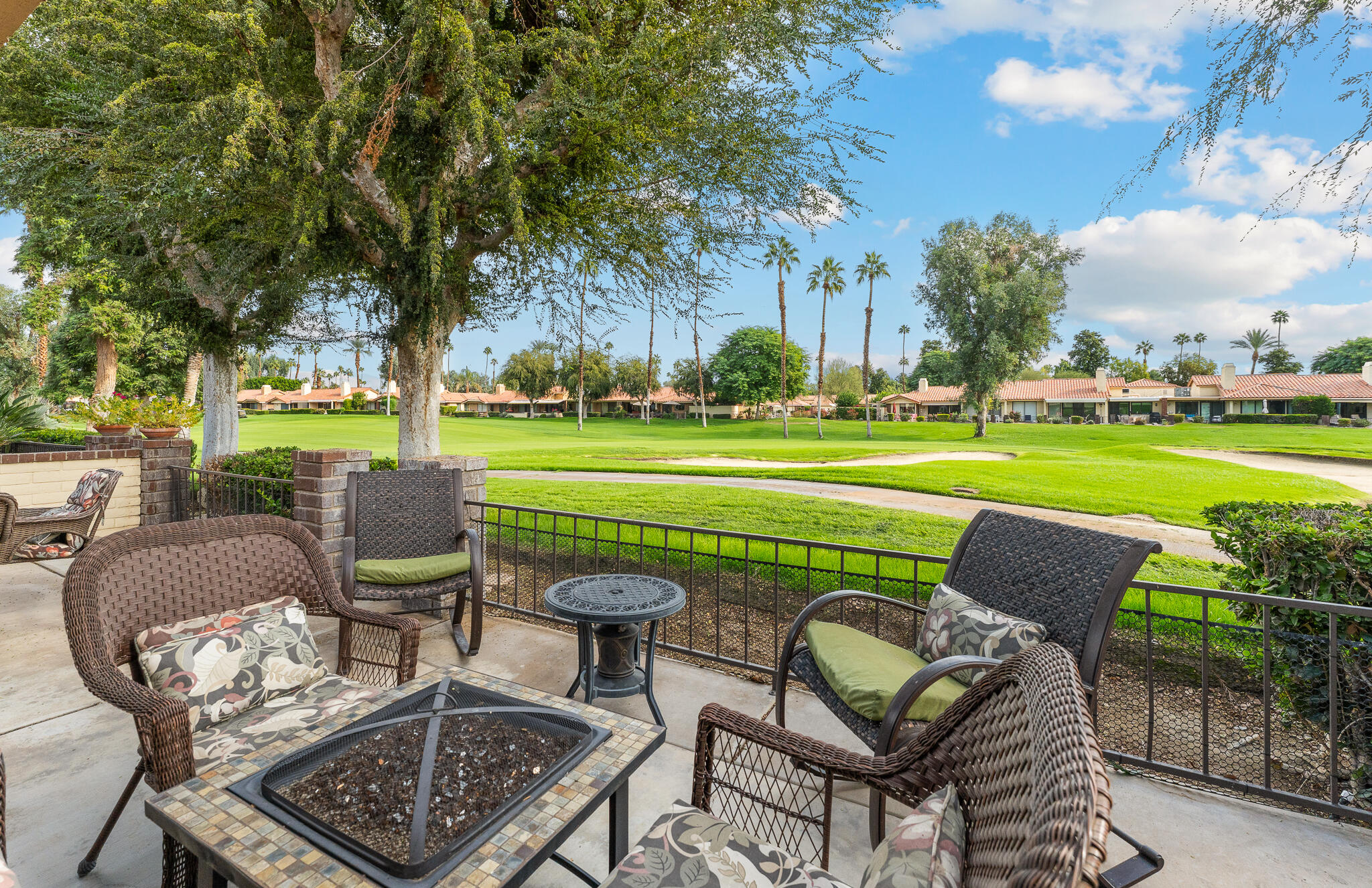 a view of a chairs and table in the patio and a backyard