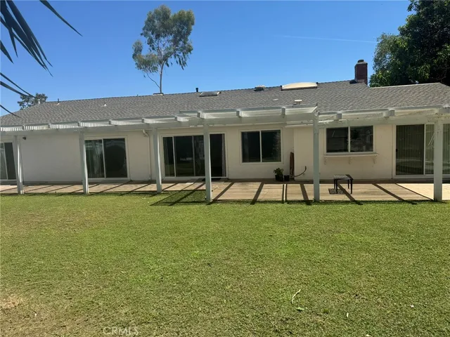 an empty room with wooden floor fireplace and windows