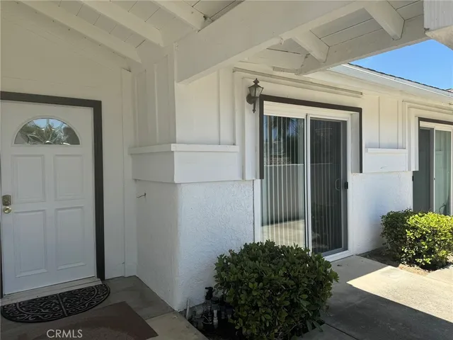 a view of a hallway with wooden floor and a potted plant