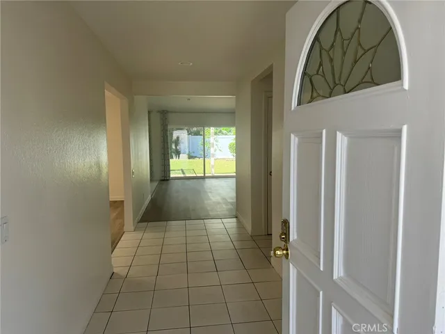 a view of an empty room with wooden floor fireplace and a window