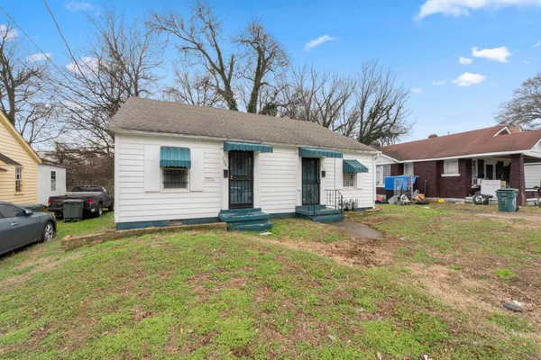 a view of a house with a yard and sitting area