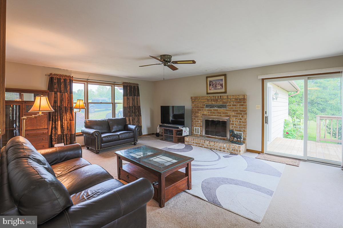 3899 Bixler Church Road Westminster, MD 21158 - Photo 6 of 42 a living room with furniture a flat screen tv and a fireplace