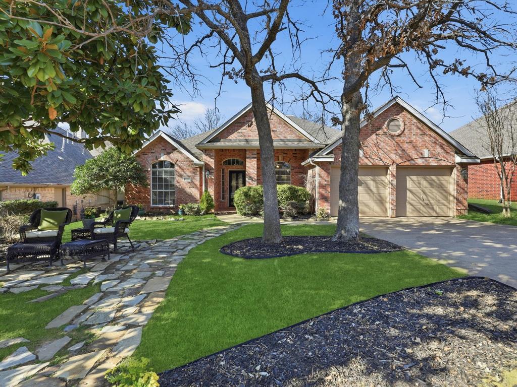 a view of house with a big yard and large trees