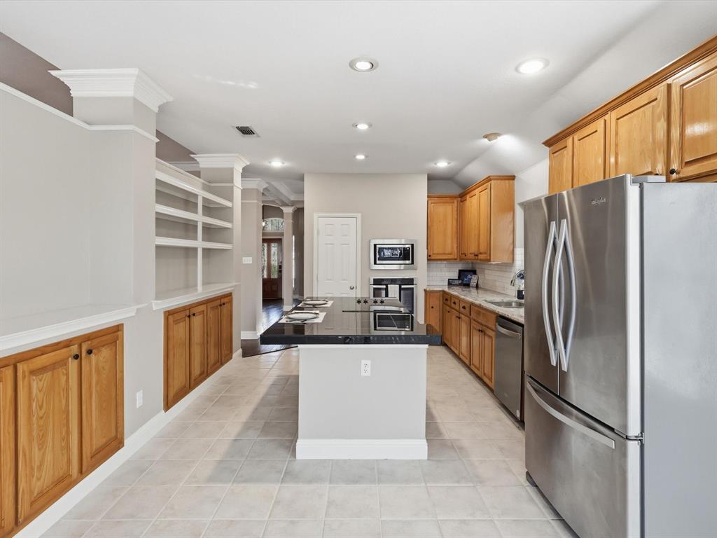 2211 Post Oak Circle Corinth, TX 76210 - Photo 10 of 40 a kitchen with granite countertop a refrigerator and cabinets