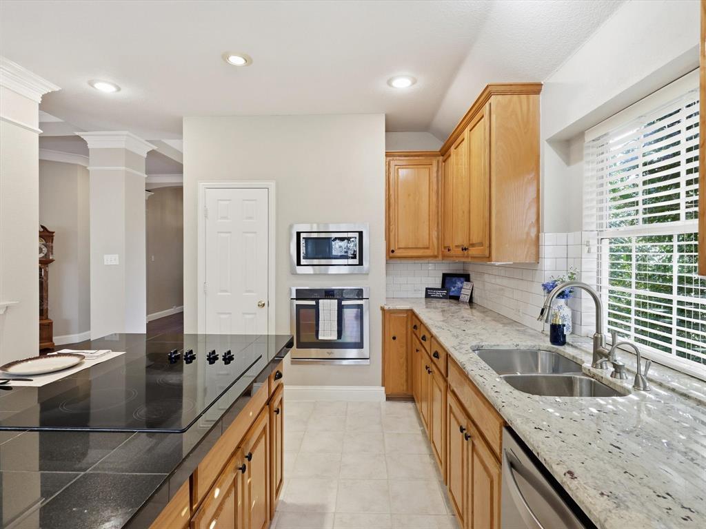 2211 Post Oak Circle Corinth, TX 76210 - Photo 12 of 40 a kitchen with stainless steel appliances granite countertop a sink a stove and a refrigerator